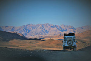 Photo of a car driving towards mountains